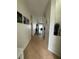 Hallway featuring neutral-colored tile flooring and light-colored walls adorned with decorative pictures at 9959 Cypress Vine Dr, Orlando, FL 32827