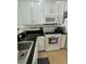 White kitchen with black countertops, stainless steel sink, and ceramic tile flooring at 9959 Cypress Vine Dr, Orlando, FL 32827