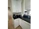Kitchen corner showcasing white cabinets with black countertops, along with appliances and decor at 9959 Cypress Vine Dr, Orlando, FL 32827