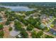 Scenic aerial view showcasing a neighborhood near a lake, surrounded by lush greenery and mature trees at 1018 Featherstone Cir, Ocoee, FL 34761