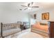 Bright bedroom featuring a metal crib, daybed, and ceiling fan for a warm and inviting space at 1018 Featherstone Cir, Ocoee, FL 34761