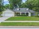 Lovely home with a lush, green lawn, white garage, and mature trees providing shade and curb appeal at 1018 Featherstone Cir, Ocoee, FL 34761