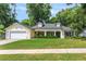Charming home with lush lawn, manicured bushes, dormer windows, and attached two car garage at 1018 Featherstone Cir, Ocoee, FL 34761