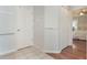Hallway with white doors, tile floor leading to wood floor bedroom with a ceiling fan at 1018 Featherstone Cir, Ocoee, FL 34761