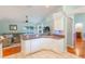 Bright open kitchen with granite countertops and white cabinetry overlooks living area with wood floors at 1018 Featherstone Cir, Ocoee, FL 34761