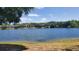 Expansive lake view surrounded by trees and well-manicured lawns on a sunny day at 1071 S Hiawassee Rd # 1211, Orlando, FL 32835