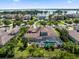 Aerial view overlooking home with screened lanai with pool & spa with lake view and lush landscaping at 11502 Waterstone Loop Dr, Windermere, FL 34786