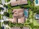 Overhead view of private home featuring screen enclosed pool and spa, lush landscaping and terracotta-tiled roof at 11502 Waterstone Loop Dr, Windermere, FL 34786