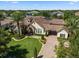 Stunning aerial view of a private home, featuring lush tropical landscaping and a terracotta-tiled roof at 11502 Waterstone Loop Dr, Windermere, FL 34786
