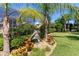 Beautifully landscaped backyard featuring a dolphin statue and mature tropical foliage at 11502 Waterstone Loop Dr, Windermere, FL 34786