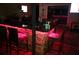 Outdoor bar area with stone base, black countertop, red accent lighting, and seating at 11502 Waterstone Loop Dr, Windermere, FL 34786