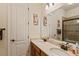 Bathroom featuring double sinks, granite countertops, modern faucets, and a shower with glass doors at 11502 Waterstone Loop Dr, Windermere, FL 34786