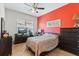 Bedroom with hardwood flooring, a ceiling fan and a large window overlooking a lush landscape at 11502 Waterstone Loop Dr, Windermere, FL 34786