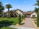 Charming home boasts lush landscaping, a brick driveway, barrel tile roof and a stone-accented façade at 11502 Waterstone Loop Dr, Windermere, FL 34786