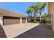 Spacious three-car garage with brick-paved driveway and mature landscaping at 11502 Waterstone Loop Dr, Windermere, FL 34786