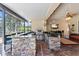 Covered outdoor kitchen with stone counter, grill, and bar seating at 11502 Waterstone Loop Dr, Windermere, FL 34786