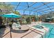 Relax poolside on a round lounge chair next to the spa in this screened pool area with brick pavers at 11502 Waterstone Loop Dr, Windermere, FL 34786