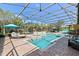 Screened pool and spa features a brick lanai, sun umbrellas and lounge chairs surrounded by lush landscaping at 11502 Waterstone Loop Dr, Windermere, FL 34786
