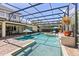 Screened pool area features a spa, brick pavers, and lounge chairs in a beautifully landscaped yard at 11502 Waterstone Loop Dr, Windermere, FL 34786