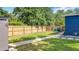 View of the backyard with a new fence, storage shed, and green lawn at 1202 Chichester St, Orlando, FL 32803