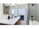 Updated bathroom featuring a modern vanity with dark fixtures and a shower-tub combo with stylish tile at 1202 Chichester St, Orlando, FL 32803