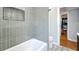 Stylish bathroom showcasing a tiled shower with a built-in niche, tiled floors, and open access to adjacent rooms at 1202 Chichester St, Orlando, FL 32803