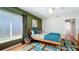 Bright bedroom featuring hardwood floors, a large window, and a bed adorned with colorful cushions at 1202 Chichester St, Orlando, FL 32803