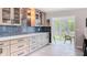 Stylish kitchen featuring gray cabinets, a blue backsplash, and an open view to the backyard patio at 1202 Chichester St, Orlando, FL 32803