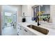Bright kitchen featuring white cabinets, black hardware, subway tile backsplash, stainless steel sink, and view to backyard at 1202 Chichester St, Orlando, FL 32803