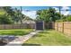 Storage shed in a fenced backyard with a manicured lawn and a stone paver walkway at 1202 Chichester St, Orlando, FL 32803