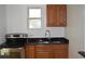 Bright kitchen showcasing stainless steel appliances, wood cabinets, and stone countertops, designed for efficient cooking at 1518 Indiana St, Orlando, FL 32805