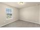 Neutral bedroom with a carpeted floor and large window overlooking neighborhood at 16043 Pebble Bluff Loop, Winter Garden, FL 34787
