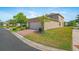 Side view of the garage and driveway with lush green landscaping and blue sky at 16043 Pebble Bluff Loop, Winter Garden, FL 34787