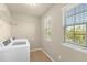 Bright laundry room with modern washer, dryer, shelving and tiled flooring at 16043 Pebble Bluff Loop, Winter Garden, FL 34787