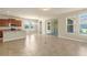Open concept living area with a kitchen island, tile floors, and sliding glass doors at 16043 Pebble Bluff Loop, Winter Garden, FL 34787