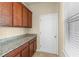 Pantry area with granite countertops, wood cabinets, and tiled floors at 16043 Pebble Bluff Loop, Winter Garden, FL 34787