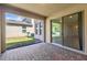 Covered patio featuring brick pavers, access to a grassy yard, and sliding glass doors at 16043 Pebble Bluff Loop, Winter Garden, FL 34787