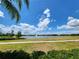 Scenic view of pond with fountain in the middle, surrounded by green grass and shrubbery under a sunny sky at 16043 Pebble Bluff Loop, Winter Garden, FL 34787