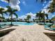 Large community pool with lounge chairs, palm trees, and a blue sky backdrop at 16043 Pebble Bluff Loop, Winter Garden, FL 34787