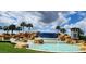 Stunning water feature with tiered waterfalls, palm trees, and blue sky at 16043 Pebble Bluff Loop, Winter Garden, FL 34787