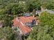Aerial view of the home showcasing its tile roof, private pool, and lush surroundings at 1716 Greystone Ct, Longwood, FL 32779