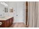 Neutral bathroom with white door, wood vanity, and shower with tile surround at 1716 Greystone Ct, Longwood, FL 32779