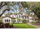 Stately two-story home with clay tile roof, manicured lawn, and mature trees providing shade and privacy at 1716 Greystone Ct, Longwood, FL 32779