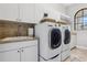 Functional laundry room with modern washer and dryer, ample storage, and a convenient sink at 1716 Greystone Ct, Longwood, FL 32779