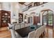 Elegant living room with fireplace, hardwood floors, tall windows, and seamless flow to the dining area at 1716 Greystone Ct, Longwood, FL 32779