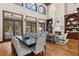 Elegant living room showcasing hardwood floors, tall windows, a fireplace, and a view of the pool at 1716 Greystone Ct, Longwood, FL 32779