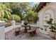 Charming outdoor patio with stone benches, table, water feature, and lush greenery at 1716 Greystone Ct, Longwood, FL 32779