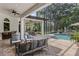 Outdoor screened patio with comfortable seating, a ceiling fan, and a glimpse of the pool area at 1716 Greystone Ct, Longwood, FL 32779