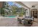 A screened pool area featuring a pool, patio furniture, tile flooring, and views of the surrounding yard at 1716 Greystone Ct, Longwood, FL 32779