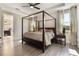 Spacious bedroom featuring a wooden canopy bed, ensuite bathroom, and wood flooring at 1909 Donahue Dr, Ocoee, FL 34761